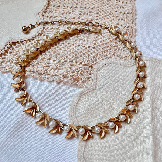 Gold Avon Evening Creation 1971 necklace with pearls on a textured fabric background